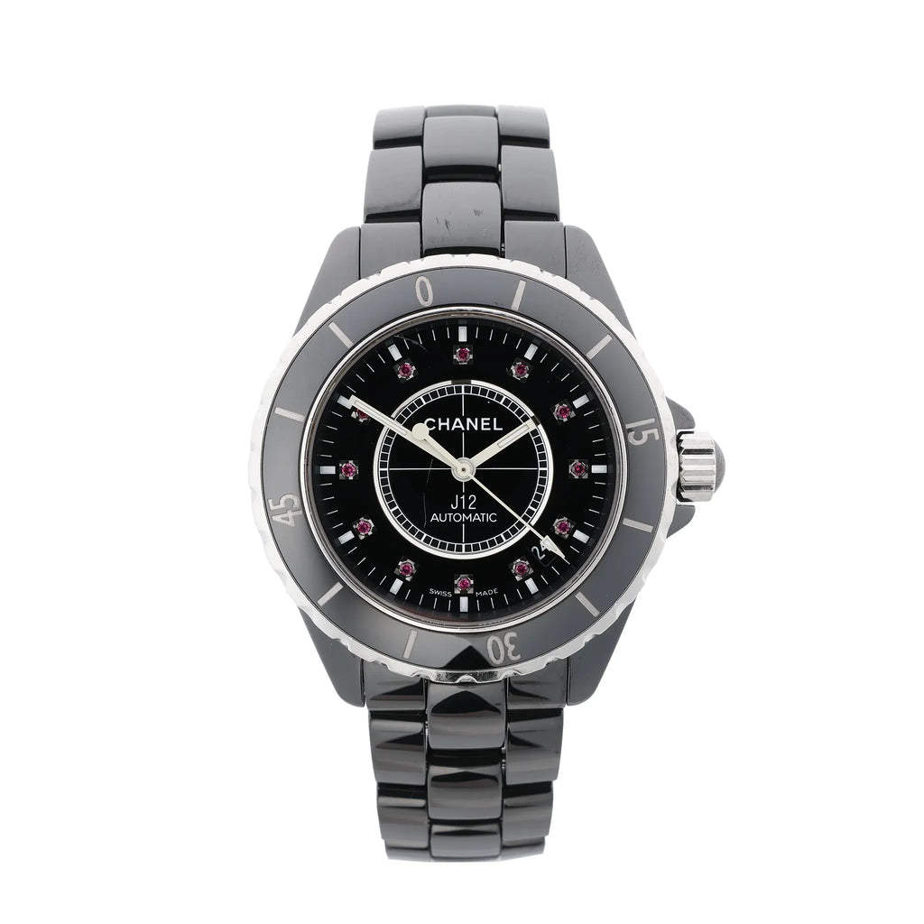 Chanel J12 automatic watch with glossy black ceramic bracelet, black dial, rotating bezel with silver-tone numerals, and pink gemstone hour markers.