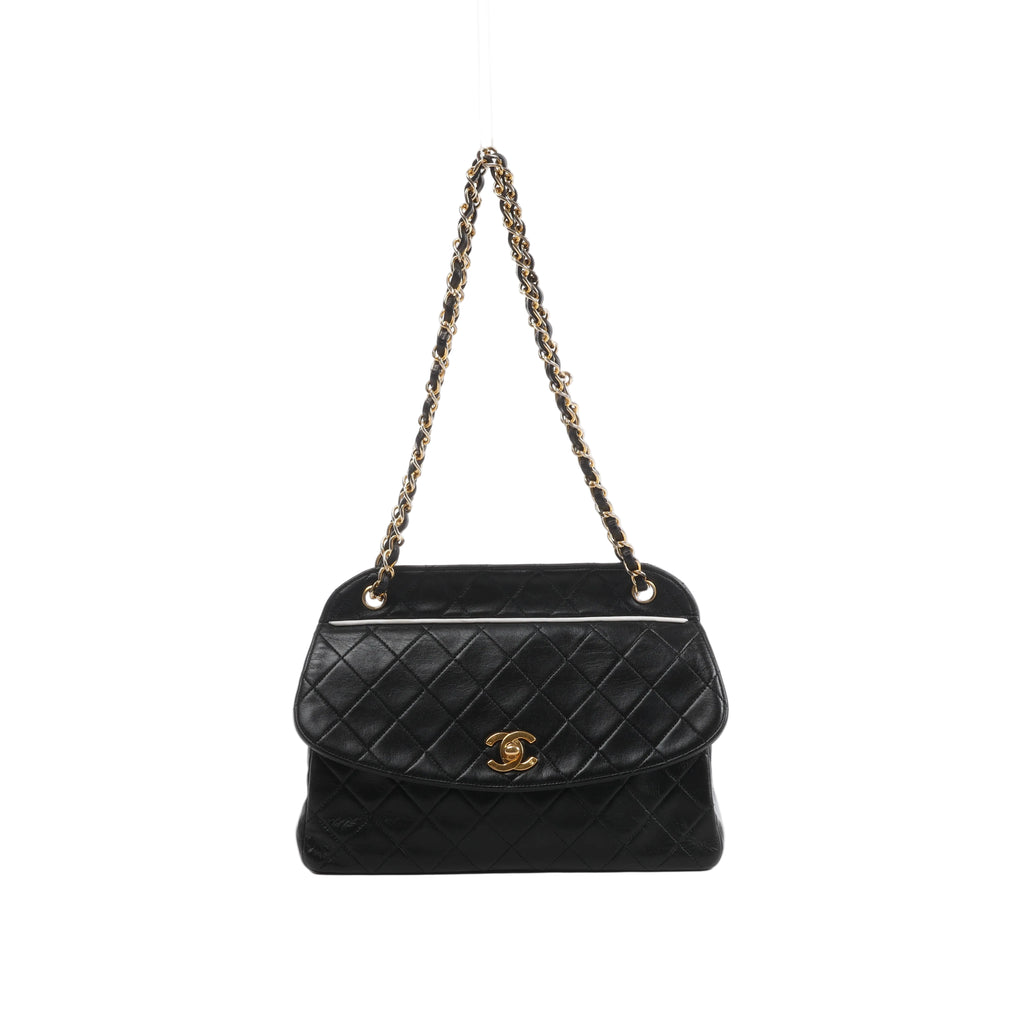 Front view of Chanel black quilted leather shoulder bag with a curved flap, gold-tone CC turn-lock and leather-threaded gold-tone chain strap.