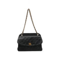 Front view of Chanel black quilted leather shoulder bag with a curved flap, gold-tone CC turn-lock and leather-threaded gold-tone chain strap.