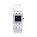 Chanel Matelassé stainless steel watch with black square dial, polished square case, quilted bracelet pattern, silver-tone hands and side crown on white background.