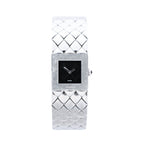 Chanel Matelassé stainless steel watch with black square dial, polished square case, quilted bracelet pattern, silver-tone hands and side crown on white background.