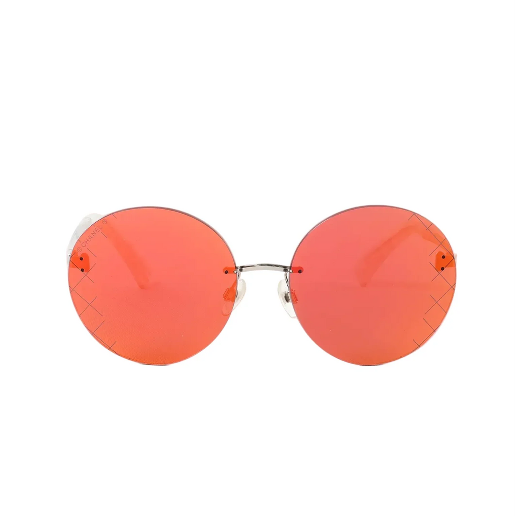 Front view of Chanel round sunglasses with red mirrored lenses and a slim silver-tone bridge on a white background.