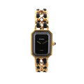 Chanel Première watch with rectangular black dial, gold-tone geometric case and chain bracelet woven with black leather.