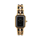 Chanel Première watch with rectangular black dial, gold-tone geometric case and chain bracelet woven with black leather.