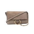 Beige Chloé Faye crossbody bag with suede flap, smooth leather base, large gold ring hardware, and gold chain strap detail.