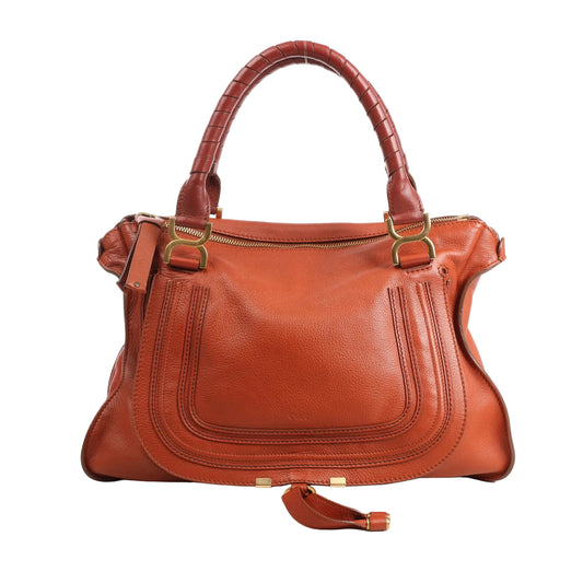 Front view of a Chloé Marcie large handbag in brown grained leather, featuring curved front stitching, dual wrapped handles, gold-tone hardware, and a top zip closure.