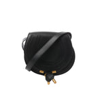 Black Chloé Marcie Mini leather crossbody bag with rounded stitched flap, gold-tone hardware accents, and adjustable shoulder strap.