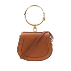 Brown Chloé Nile leather handbag with rounded saddle shape, large gold-tone bracelet handle and slim shoulder strap.