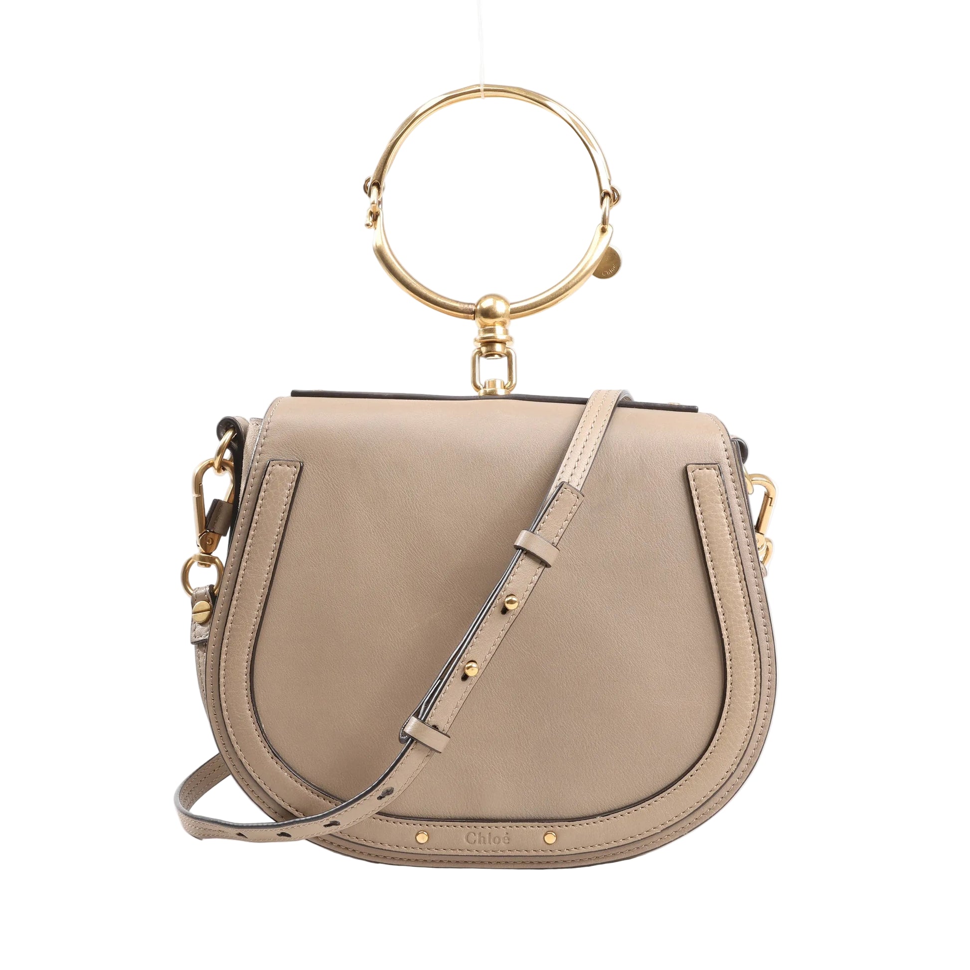 Chloé Nile Small 2Way Shoulder Bag in beige leather with gold-tone metal ring handle, adjustable crossbody strap, and curved saddle silhouette on a white background.