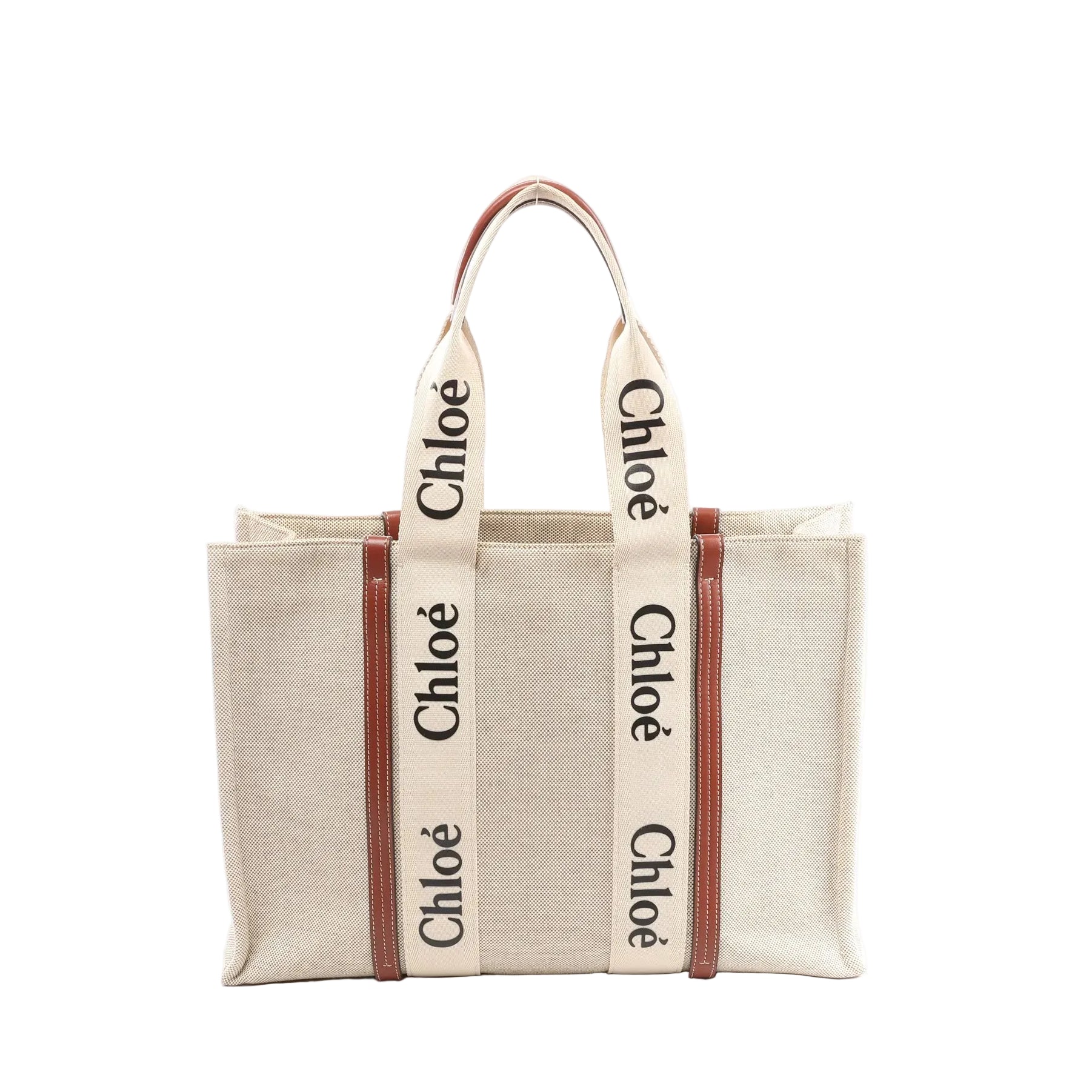 Chloé Woody Large beige canvas tote with brown leather trim and wide logo webbing straps, front view on white background.