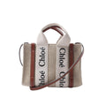 Chloé Woody Mini handbag in beige canvas with brown leather trim, logo webbing top handles and a slim detachable shoulder strap.