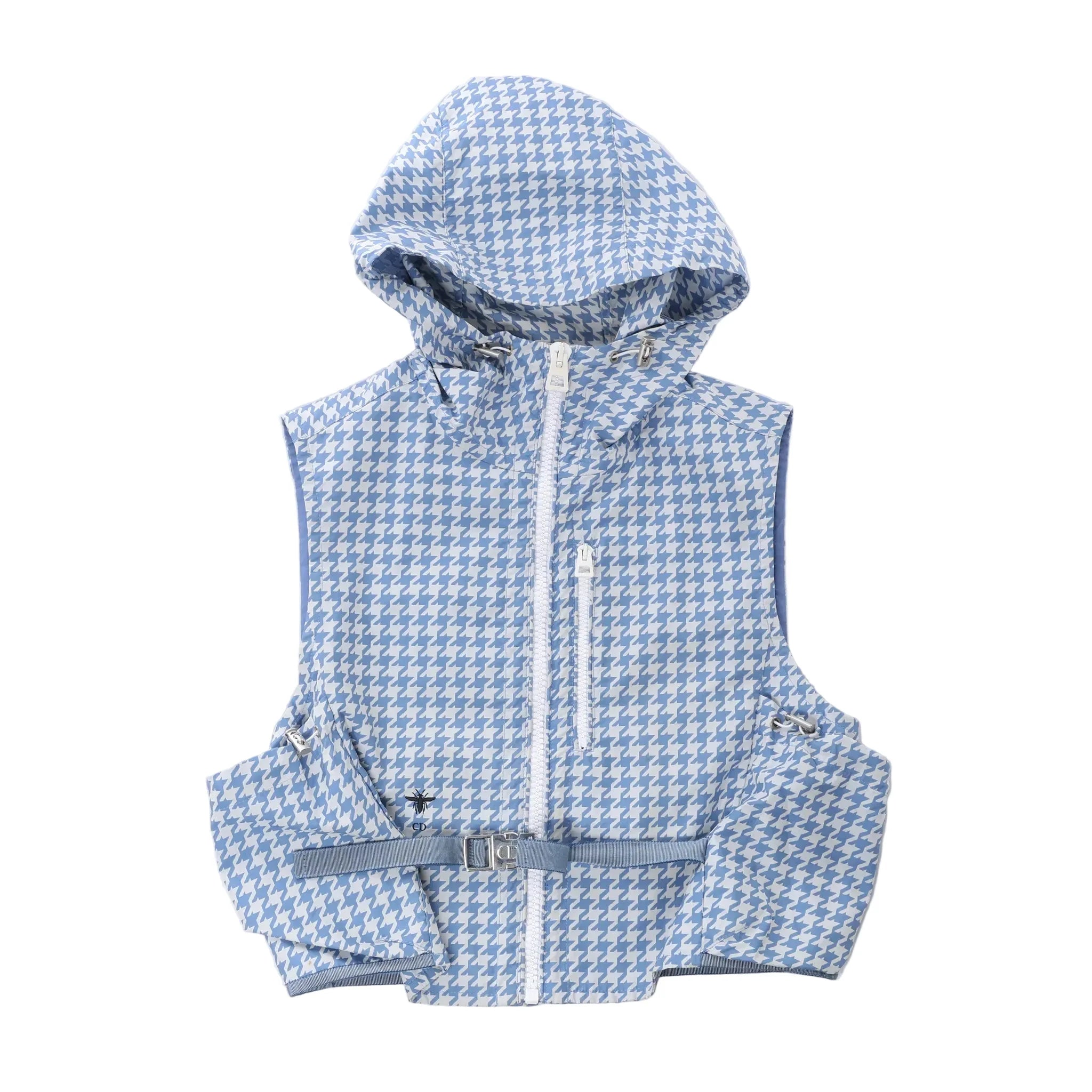 Christian Dior sleeveless hooded vest in blue and white houndstooth pattern with front zip closure, chest zip pocket, utility pockets and adjustable waist belt on white background.