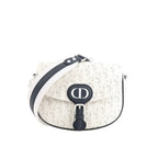 White Dior Bobby Small crossbody bag with perforated Oblique pattern, navy CD front buckle, navy trim, and wide white-and-navy shoulder strap.