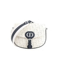 White Dior Bobby Small crossbody bag with perforated Oblique pattern, navy CD front buckle, navy trim, and wide white-and-navy shoulder strap.