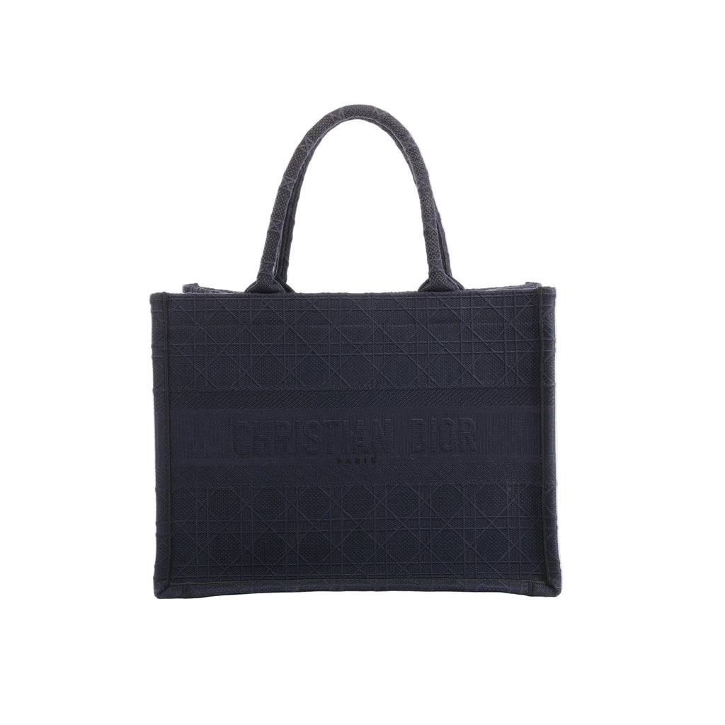 Front view of Christian Dior Book Tote in navy blue canvas with a tonal Cannage pattern, Christian Dior Paris lettering and twin handles.