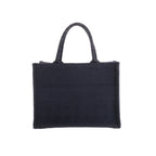 Front view of Christian Dior Book Tote in navy blue canvas with a tonal Cannage pattern, Christian Dior Paris lettering and twin handles.