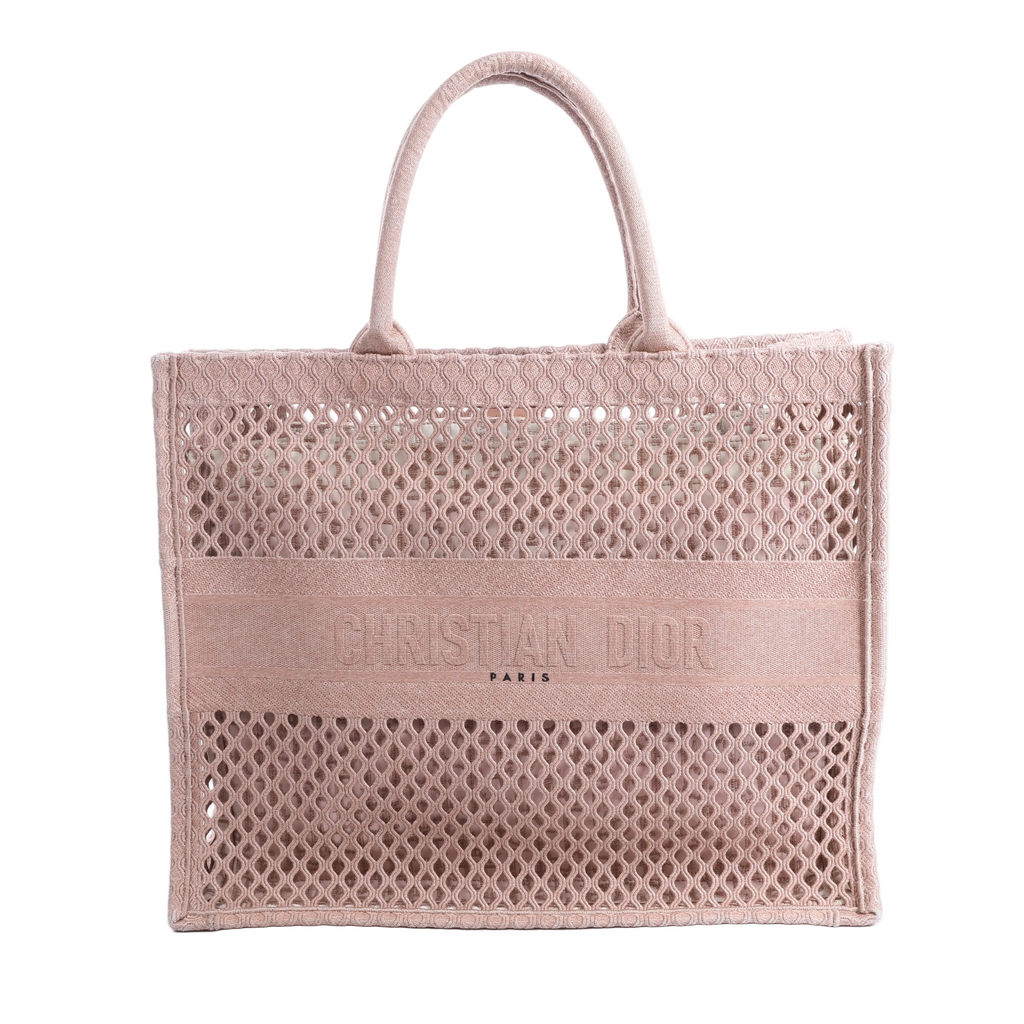 Pink Christian Dior Book Tote Large mesh bag with openwork pattern, dual top handles and CHRISTIAN DIOR PARIS lettering across the front.