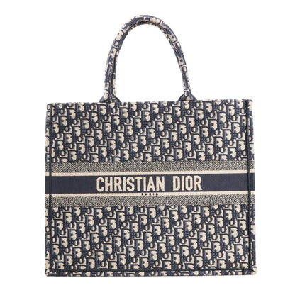 Dior Book Tote large shoulder bag in navy blue Oblique canvas with all-over “Dior” monogram pattern and bold “Christian Dior Paris” logo embroidered across the front.