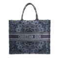 Christian Dior Book Tote Large shoulder bag in navy blue Kaleidiorscopic embroidered canvas with intricate symmetrical patterns, top handles, and bold "Christian Dior Paris" logo across the front.