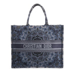 Christian Dior Book Tote Large shoulder bag in navy blue Kaleidiorscopic embroidered canvas with intricate symmetrical patterns, top handles, and bold "Christian Dior Paris" logo across the front.