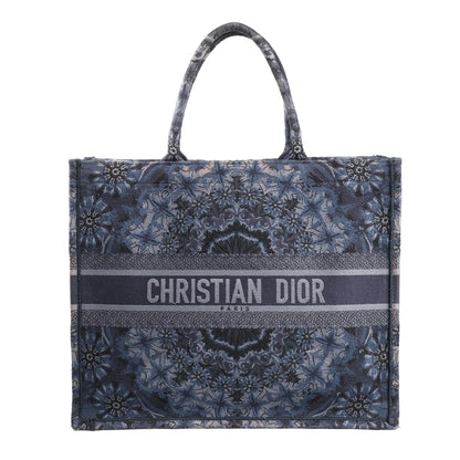Christian Dior Book Tote Large shoulder bag in navy blue Kaleidiorscopic embroidered canvas with intricate symmetrical patterns, top handles, and bold "Christian Dior Paris" logo across the front.