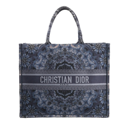 Christian Dior Book Tote Large shoulder bag in navy blue Kaleidiorscopic embroidered canvas with intricate symmetrical patterns, top handles, and bold "Christian Dior Paris" logo across the front.