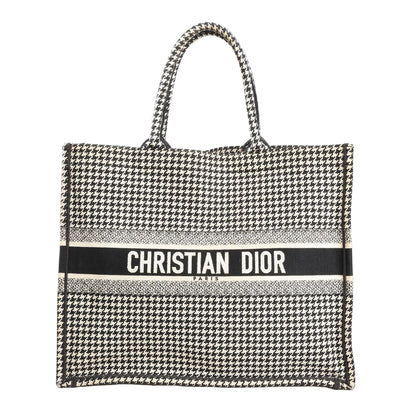 Christian Dior Book Tote Large canvas shoulder bag in black and white featuring an all-over houndstooth pattern with “CHRISTIAN DIOR PARIS” embroidered across the front and dual top handles.