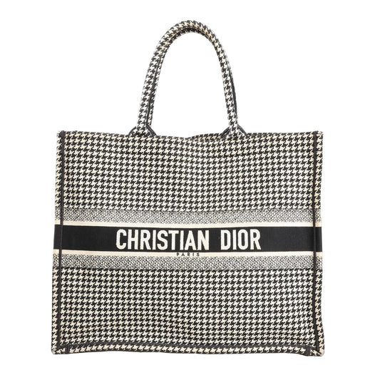 Christian Dior Book Tote Large canvas shoulder bag in black and white featuring an all-over houndstooth pattern with “CHRISTIAN DIOR PARIS” embroidered across the front and dual top handles.