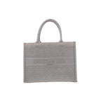 Front view of Christian Dior Book Tote Medium in gray canvas with a tonal Cannage pattern, Christian Dior Paris lettering and matching twin handles.