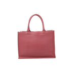 Front view of Christian Dior Book Tote Medium in pink leather with tonal embossed Christian Dior Paris lettering and matching rounded twin handles.