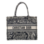 Navy blue Christian Dior Book Tote Medium with Toile de Jouy embroidered wildlife motifs, dual top handles and CHRISTIAN DIOR PARIS logo band.