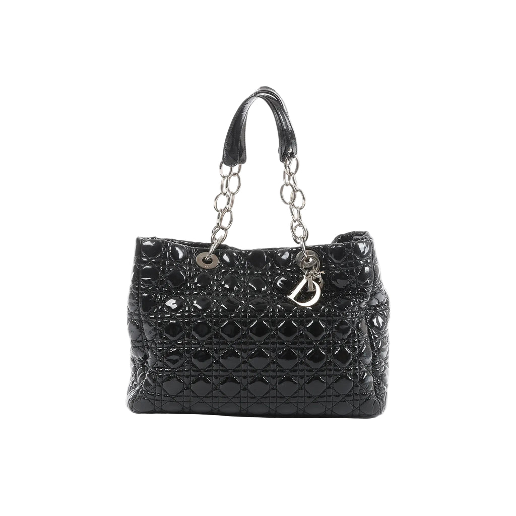 Front view of Dior Soft Lady Dior Large bag in black patent leather with Cannage quilting, silver-tone chain-and-leather handles, and hanging D.I.O.R. letter charms.
