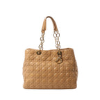 Beige patent leather Dior Soft Lady Dior large shoulder bag with Cannage quilting, gold-tone chain shoulder handles with beige leather pads, and Dior letter charm.