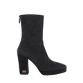 Side view of a black suede Dior boot with a rounded toe, front platform, tall block heel, gold-tone DIOR heel lettering and a back zip.