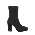 Side view of a black suede Dior boot with a rounded toe, front platform, tall block heel, gold-tone DIOR heel lettering and a back zip.