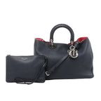 Navy blue Christian Dior Diorissimo grained leather handbag with top handles, shoulder strap, silver-tone Dior charms, red interior and matching zip pouch.