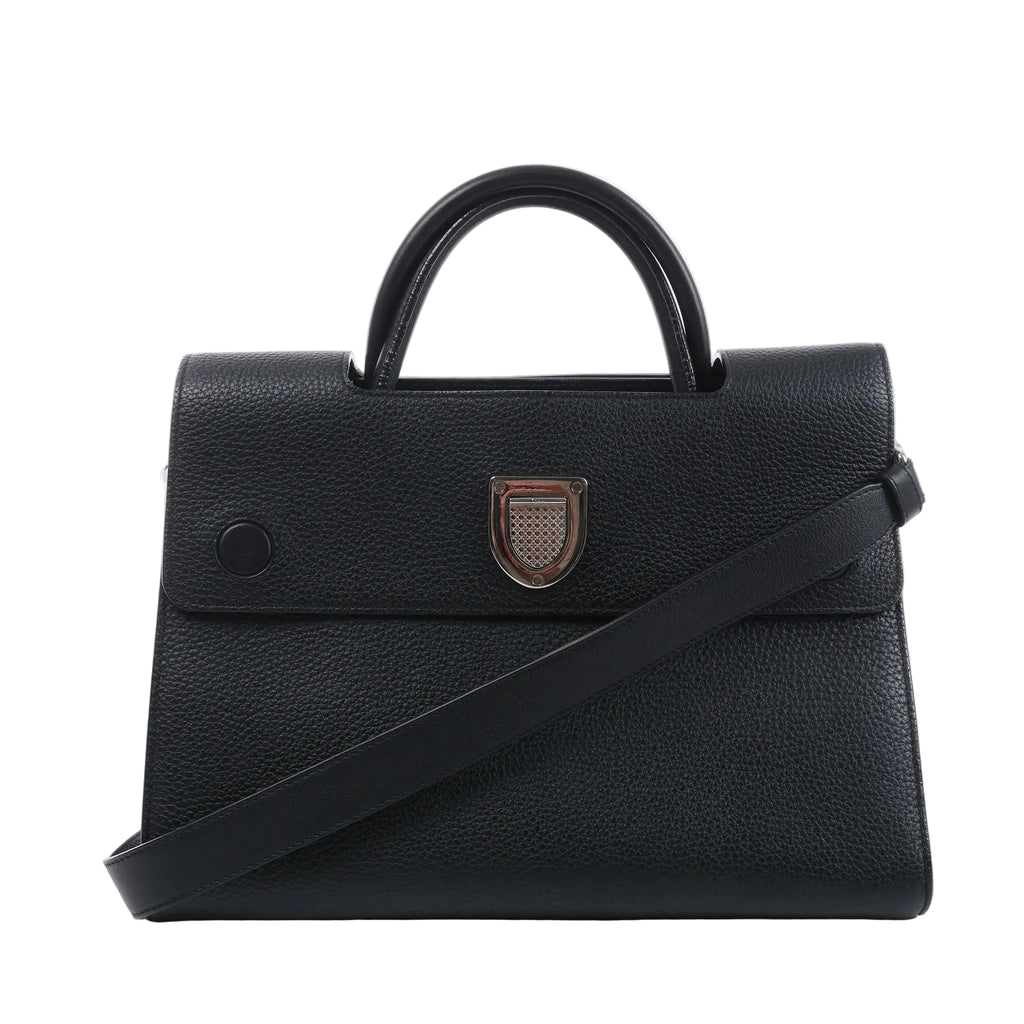 Front view of a black Dior Diorever grained leather handbag with a rounded top handle, silver-tone shield clasp and shoulder strap.