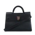 Front view of a black Dior Diorever grained leather handbag with a rounded top handle, silver-tone shield clasp and shoulder strap.