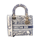 Beige and navy Christian Dior Lady D-Lite canvas bag with Toile de Jouy animal print, CHRISTIAN DIOR logo band, top handles, wide strap and gold-tone charms.