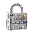 Beige and navy Christian Dior Lady D-Lite canvas bag with Toile de Jouy animal print, CHRISTIAN DIOR logo band, top handles, wide strap and gold-tone charms.