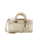 Dior Lady D-Joy Racing beige handbag with lace-style embroidered detailing, top handle, chain-accent shoulder strap, and silver-tone DIOR letter charms on a white background.