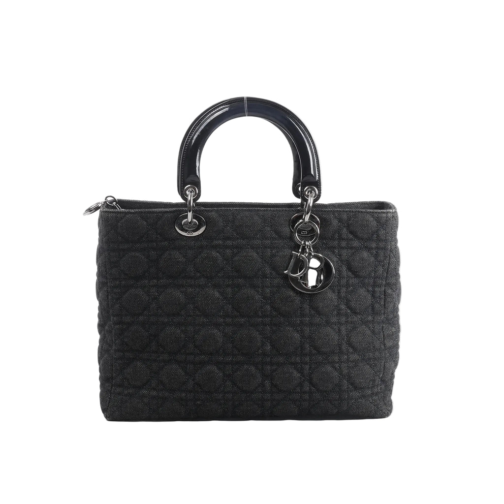 Front view of Dior Lady Dior Large handbag in black Cannage quilted denim with glossy black top handles, silver-tone hardware, and hanging DIOR letter charms.