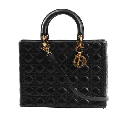 Front view of the Dior Lady Dior Large Cannage 2Way Handbag in black lambskin leather, featuring signature quilted Cannage stitching, structured top handles, detachable shoulder strap, and gold-tone hardware with dangling "Dior" letter charms.