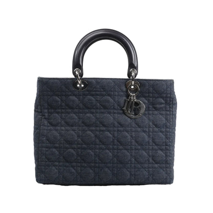 Dior Lady Dior Large Handbag in blue denim with signature Cannage quilted stitching, black leather top handles, and silver-tone hardware including dangling Dior letter charms, displayed against a white background.