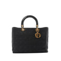 Dior Lady Dior Large black Cannage quilted nylon handbag with patent top handles, gold-tone ring hardware, and dangling DIOR letter charms on a white background.