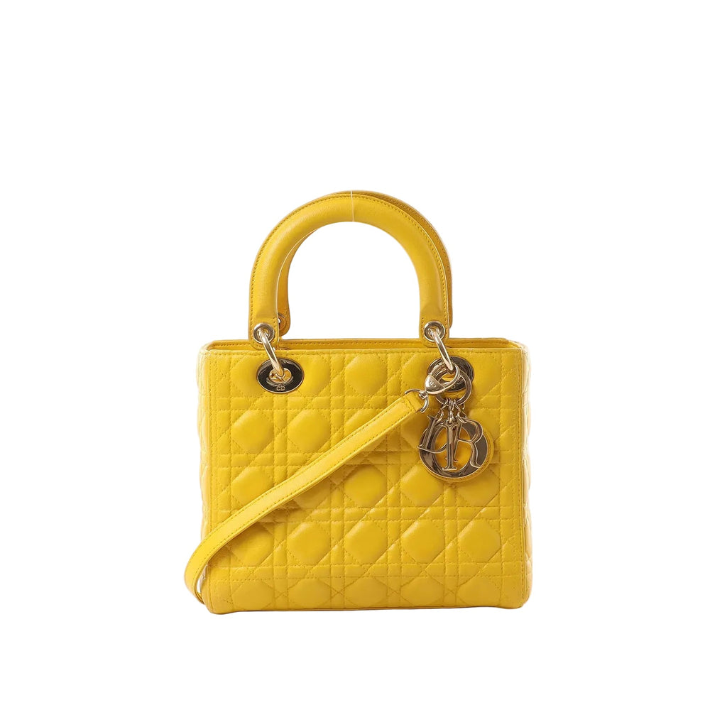 Yellow Dior Lady Dior leather handbag with Cannage quilting, rounded top handles, shoulder strap, and hanging Dior letter charms
