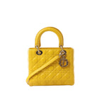 Yellow Dior Lady Dior leather handbag with Cannage quilting, rounded top handles, shoulder strap, and hanging Dior letter charms