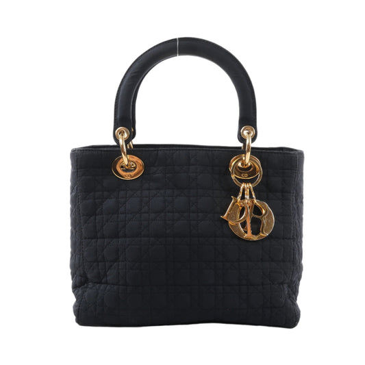 Black quilted handbag with gold hardware on a white background