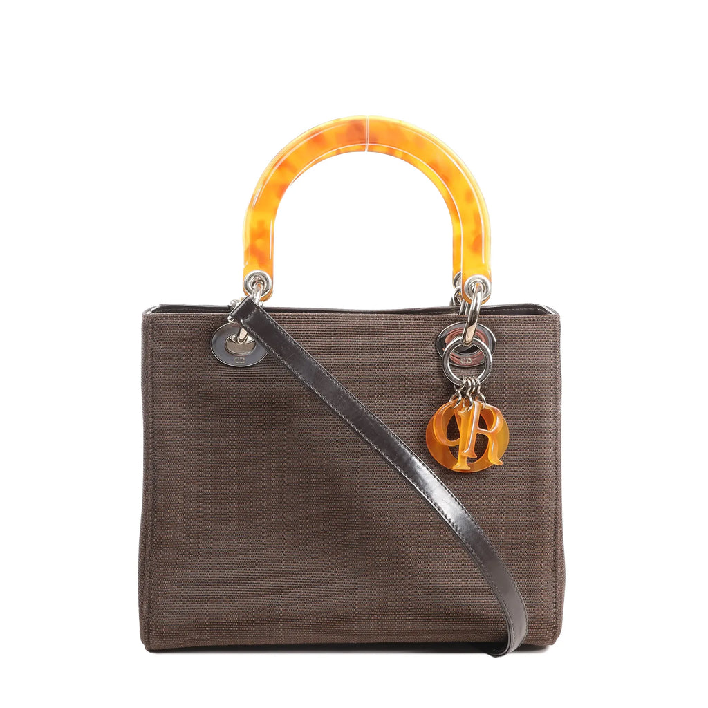 Dior Lady Dior 2Way handbag in brown Cannage nylon with black leather strap, amber-tone resin handles, and signature hanging “Dior” charms.