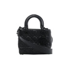 Front view of Christian Dior My Lady Dior black leather handbag with Cannage quilting, rounded handles, black DIOR charms and a broad shoulder strap.